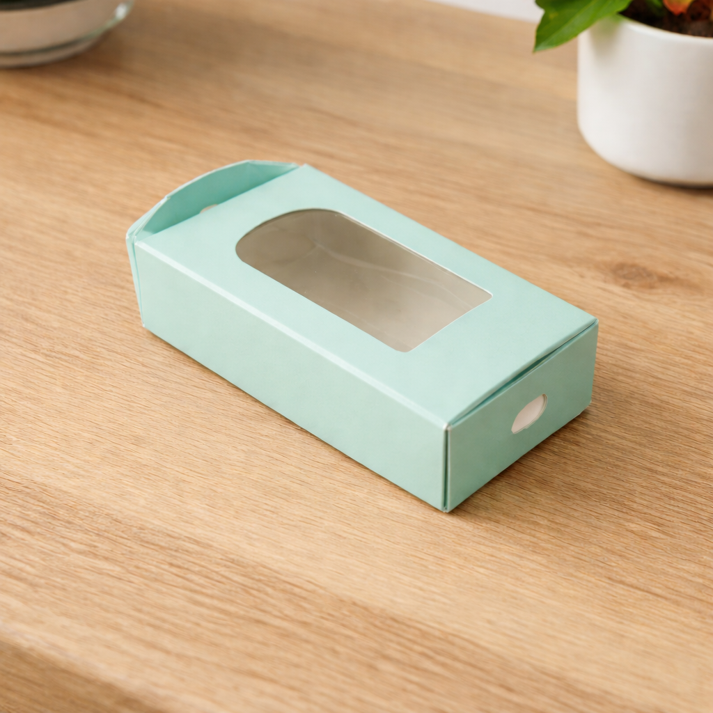 pastel green window caksicle packaging box with a clear display window on a wooden surface